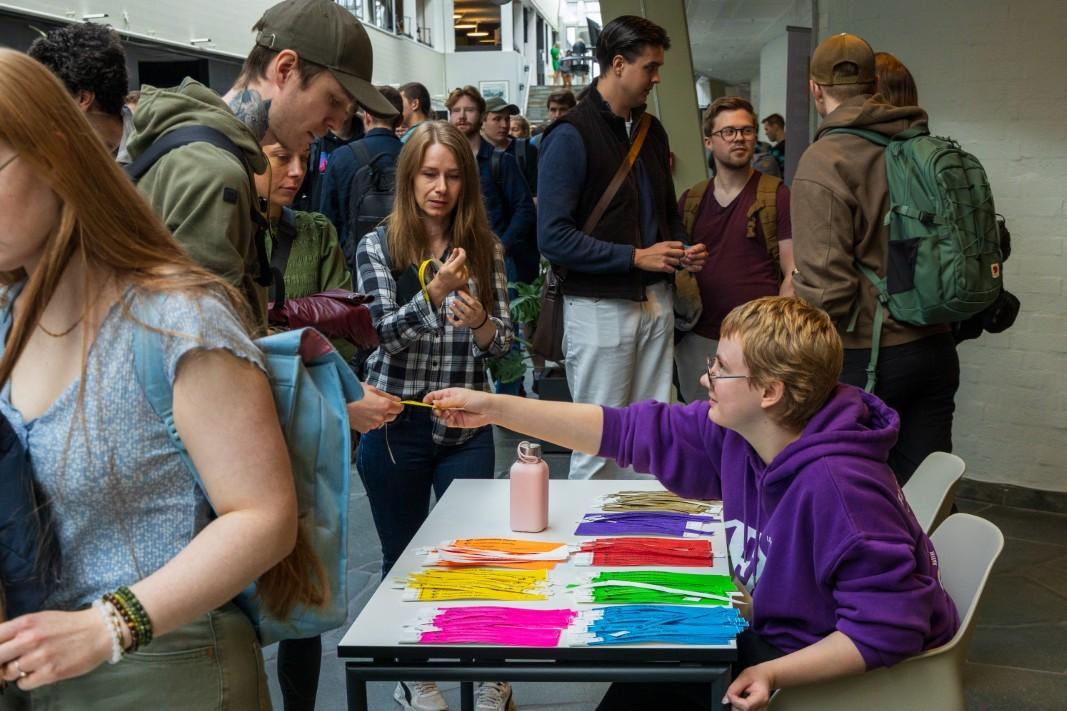 Lillakledd fadder deler ut info til nye studenter.